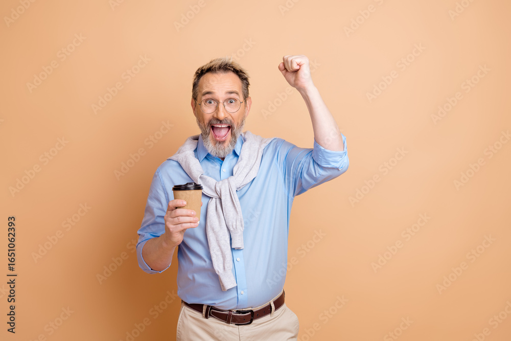Cheerful senior businessman showing excitement holding coffee cup in modern casual outfit against beige background Cheerful senior businessman showing excitement holding coffee cup in modern casual outfit against beige background