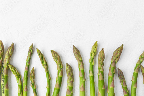 Tableau sur toile Green asparagus spears arranged on white background with copy space