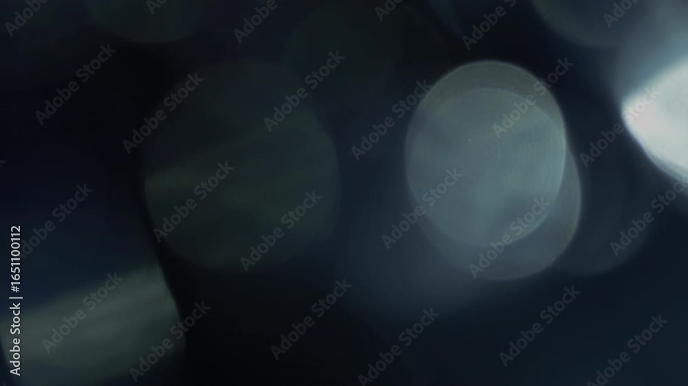 Video transition and through moving light beam from right to left and with blue bokeh reflections with light leaks.