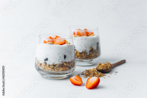 Yogurt parfaits topped with sliced strawberries and granola