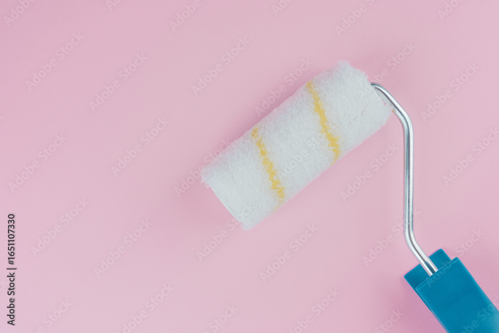 Obraz premium Single blue handled roller on pink background for minimalism and painting concept