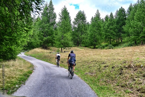 couple of gravel bikers backview riding in scenic mountain environment