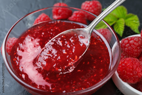 Wallpaper Mural Taking sweet raspberry jam with spoon from glass bowl on gray table, closeup Torontodigital.ca