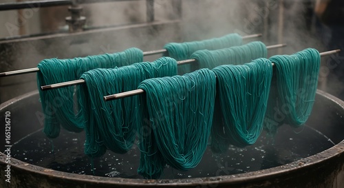 Green yarn being dyed in industrial vat 