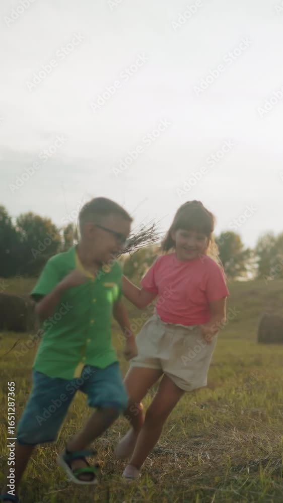 Joyful siblings run and play in open countryside, with girl chasing her ...