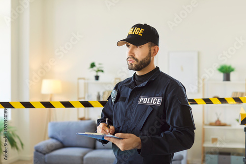 Fotografie Indoor shot of serious police officer filling in documents, regarding police inv