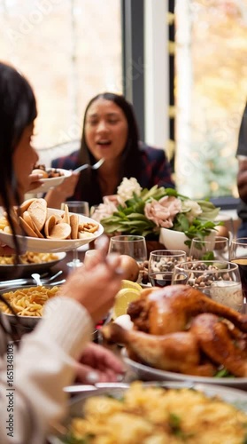 Friendsgiving - friends gathering for a traditional thanksgiving turkey dinner