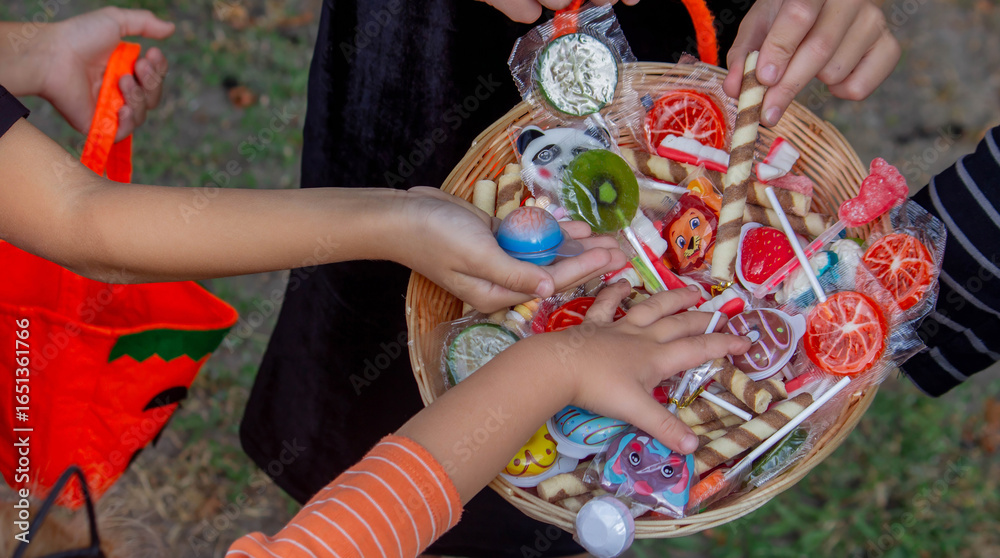 Fototapeta premium Children collecting candy for Halloween. Selective focus