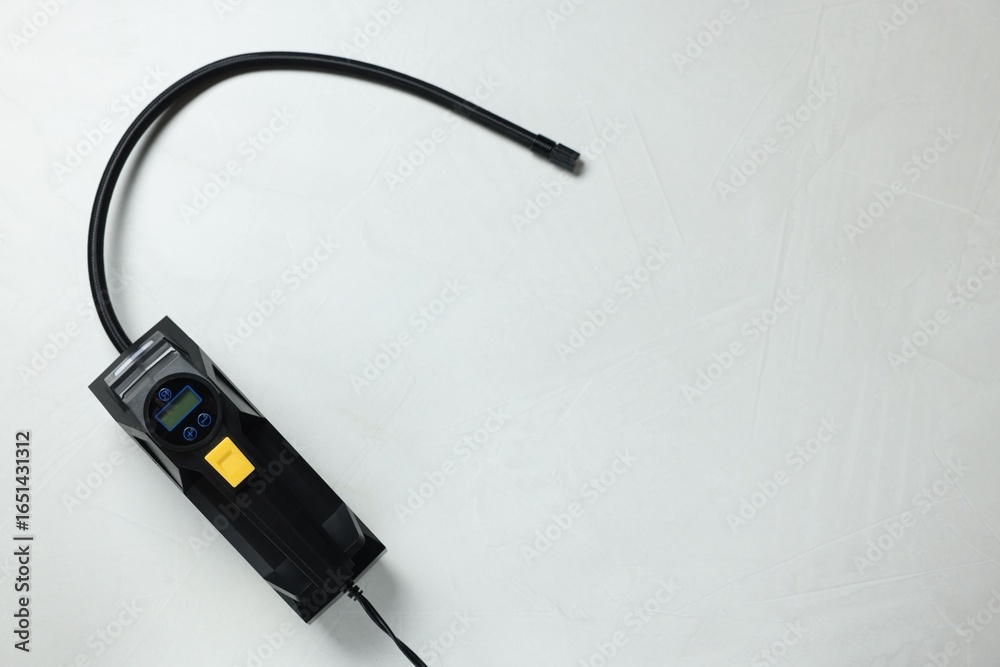 Obraz premium One tire inflator on light background, top view. Space for text
