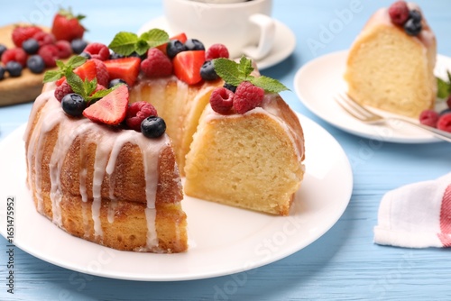 Wallpaper Mural Pieces of delicious bundt cake with berries, glaze and mint on light blue wooden table, closeup Torontodigital.ca