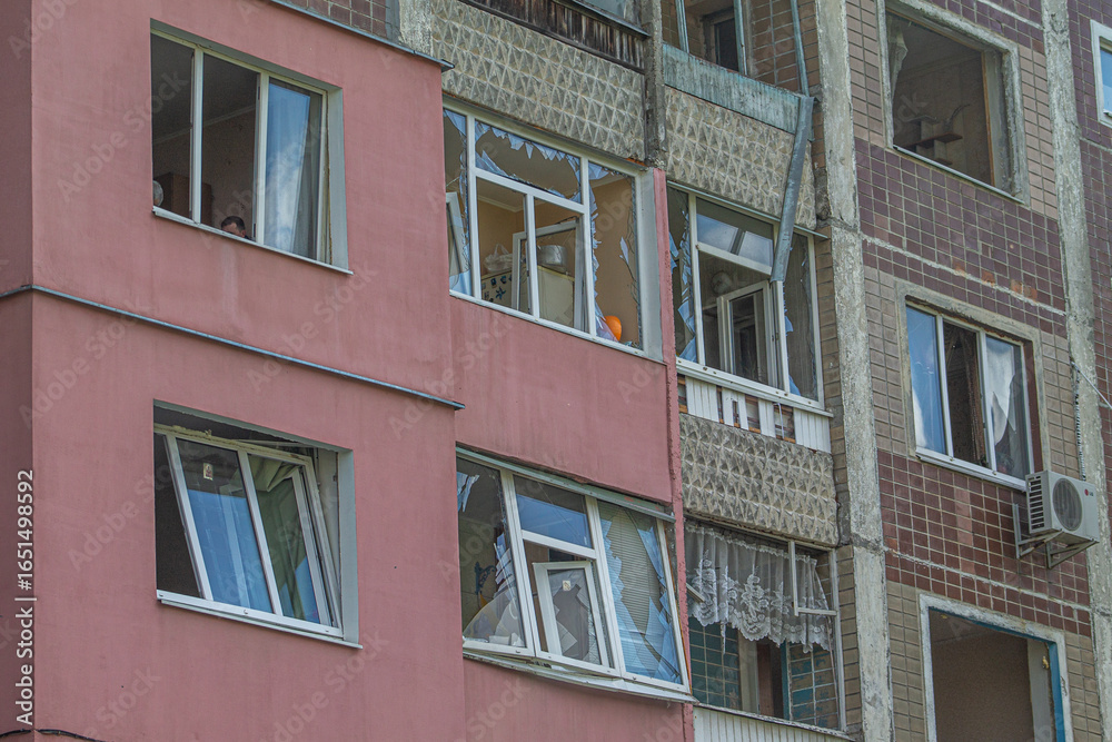 Fototapeta premium Facade of a residential building with broken windows after shelling