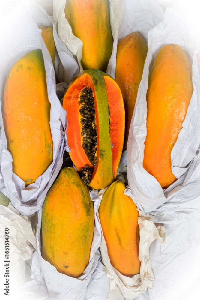 Φωτογραφία Sectional view of cut Papaya fruit with other raw papaya fruits for sale in Indian market