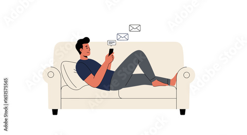 Relaxed young man in casual clothes lying on a sofa, checking messages on his smartphone.