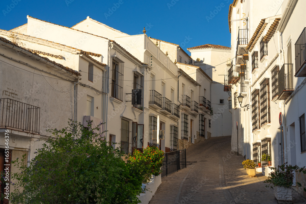 Obraz premium White village of Zahara de la Sierra at sunset with the church and the castle in the Cadiz province of Spain.