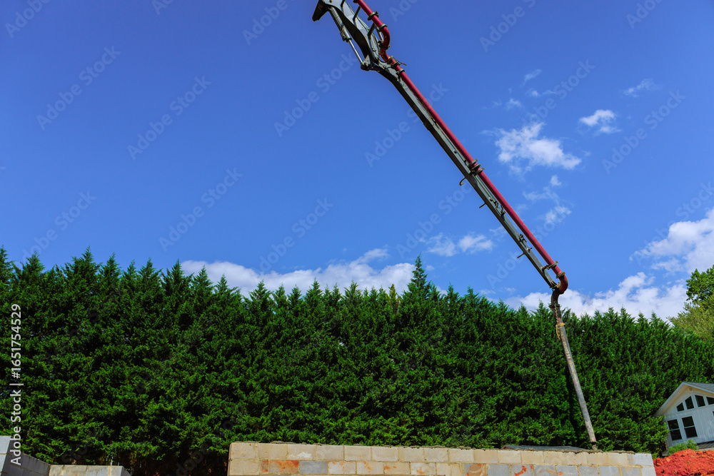 Obraz premium Construction site with concrete pump pouring for building foundation on works day