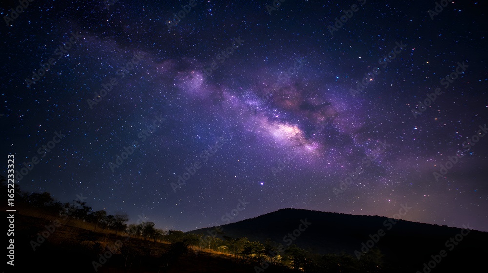 Fototapeta premium Milky way galaxy over a dark mountain range.