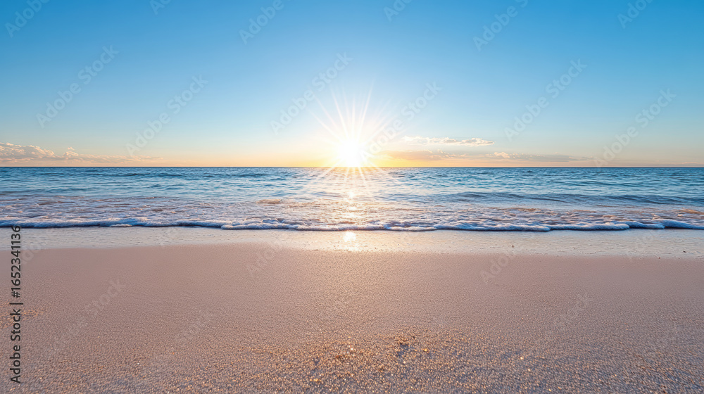 Obraz premium Sunrise over calm ocean waves creates serene beach scene with soft sand and clear sky