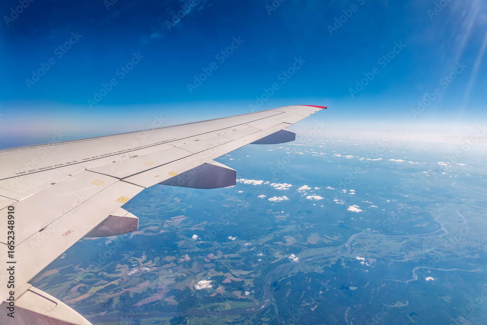 Obraz premium View from the airplane window at a beautiful cloudy sky and the airplane wing