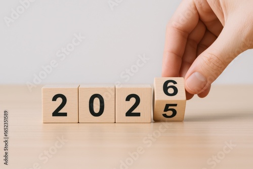 Wooden Blocks Displaying Year 2026 with Hand, Forecasting New Year Goals and Future Predictions
