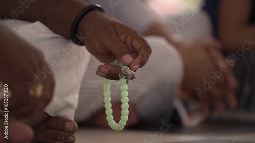Closeup shot of hand with chanting beads. Spirituality and faith.