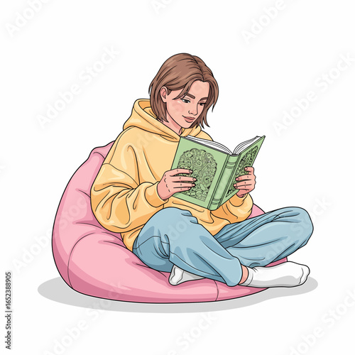 A young woman in a yellow hoodie sits on a pink beanbag chair, engrossed in reading a green book.