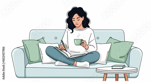 Woman writing in journal with coffee on sofa, cozy home lifestyle