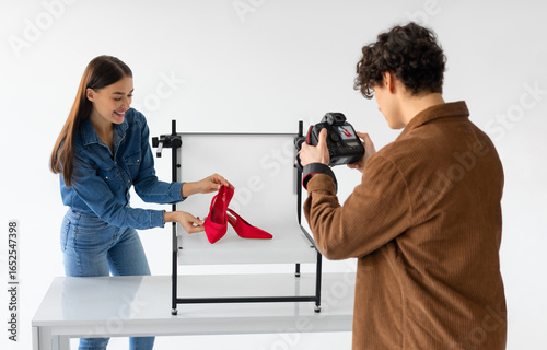 Fényképezés Professional male photographer and his female assistant doing content photoshoot