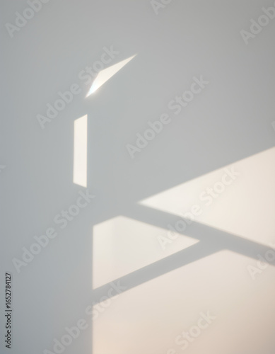 Minimal sunlight and window shadows on white wall