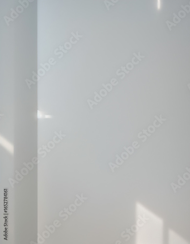 Minimal sunlight and window shadows on white wall