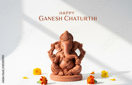 Minimalistic poster of a clay Lord Ganesha idol placed on a clean white background, marigold flowers, typography at Happy Ganesh Chaturthi’