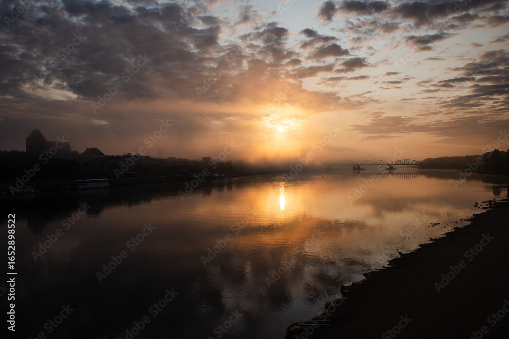 Fototapeta premium sunrise over the foggy river in Toruń