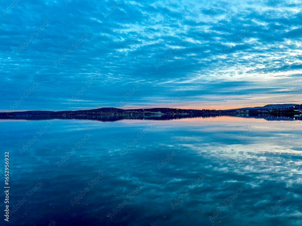 Fototapeta premium Sunset above the baltic sea in Örnsköldsvik harbor with water reflections, Sweden