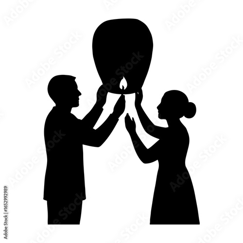 Couple silhouettes releasing a sky lantern at night