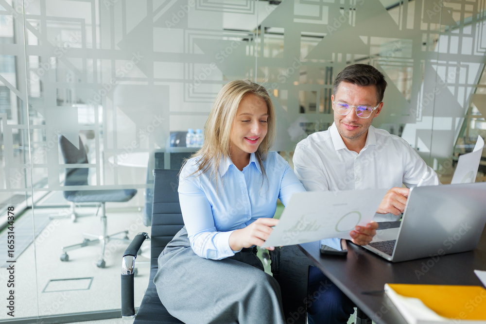 Obraz premium Colleagues engaging in a productive discussion about project details in a modern office setting