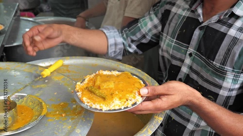 Slow motion dalcha pouring over hot steamed rice