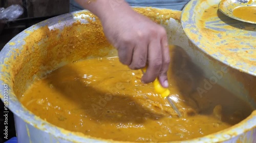 Slow motion footage of dalcha being stirred in a big pot