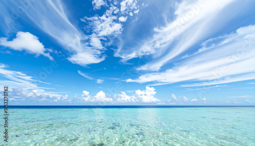 Fototapeta Naklejka Na Ścianę i Meble -  Serene Tropical Seascape:  Azure Waters,  Wispy Clouds,  Bright Sunny Day,  Tranquil Ocean View,  Perfect Summer Vacation.