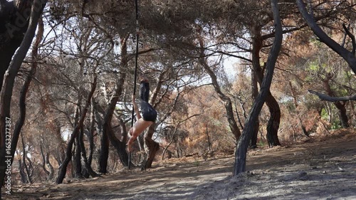 Male Circus Artist Performing Pole Dance on Aerial Pole in Forest Outdoors