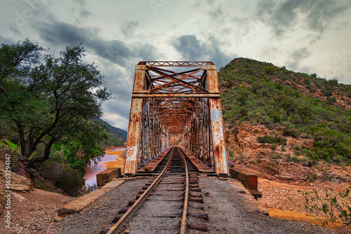 Old Rusty Railway Bridge Over a Red River