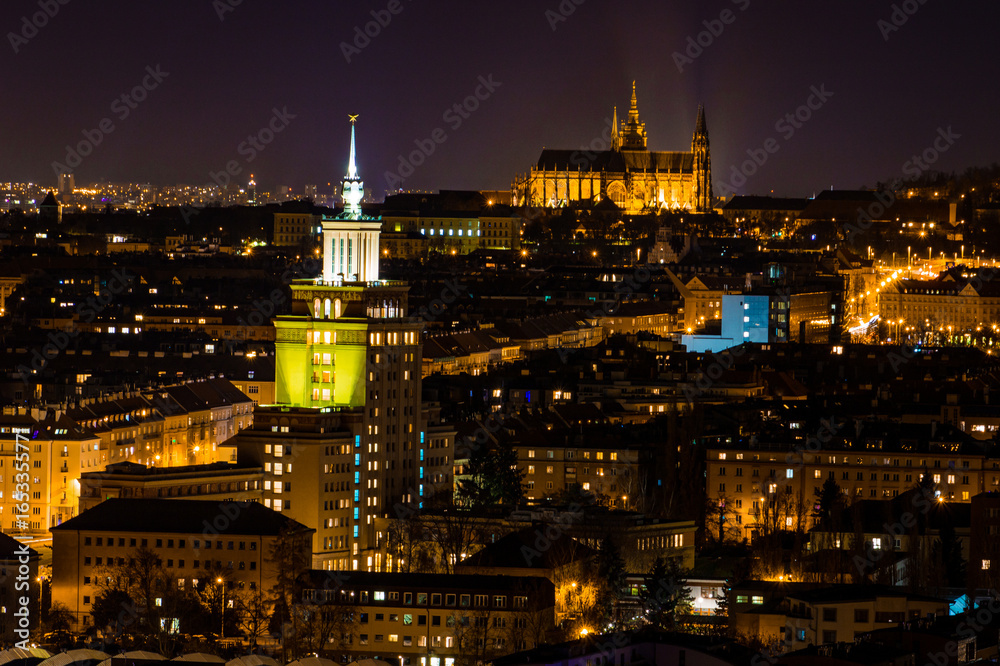 Naklejka premium Night view of Prague, Czech Republic, with illuminated Prague Castle and the Church of St. Vitus in the background.
