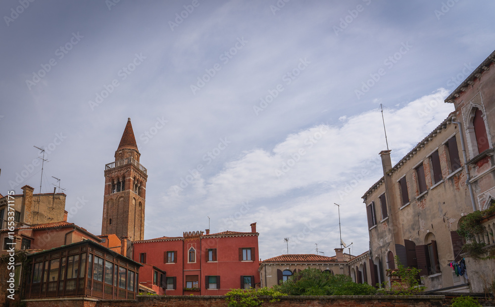 Naklejka premium Venetian brick bell tower seen from canal and street