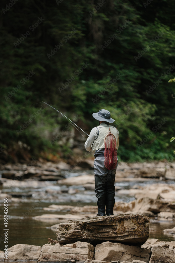 Fisherman casting line in river, catching trout on a cloudy day Fisherman casting line in river, catching trout on a cloudy day