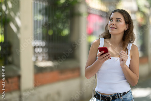 Fotografie Smiling curious young girl around 20 years old stopping briefly while exploring