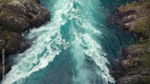 Looking down onto a fast flowing blue river below.