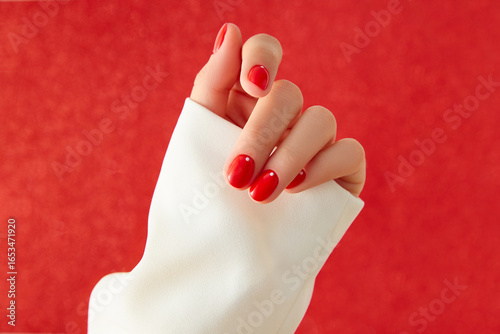 Close up womans hand with red minimalist nail design. Manicure, pedicure beauty salon concept