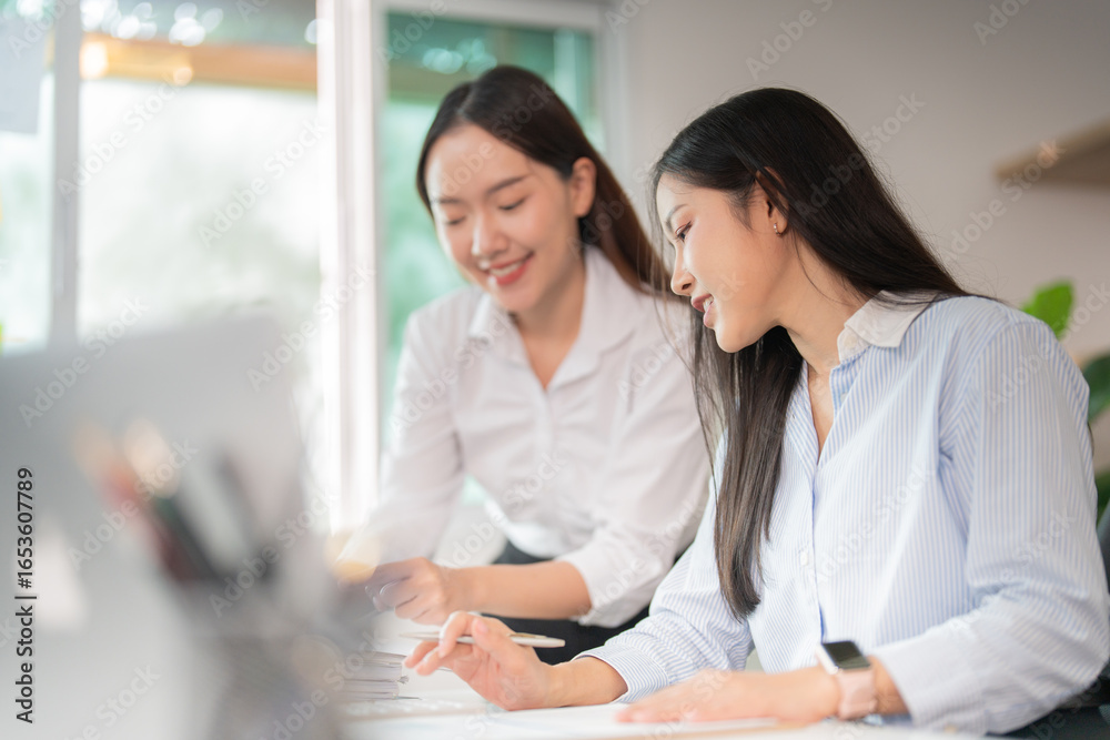 Obraz premium Collaboration in the Workplace: Two Women Engaging in Productive Discussion