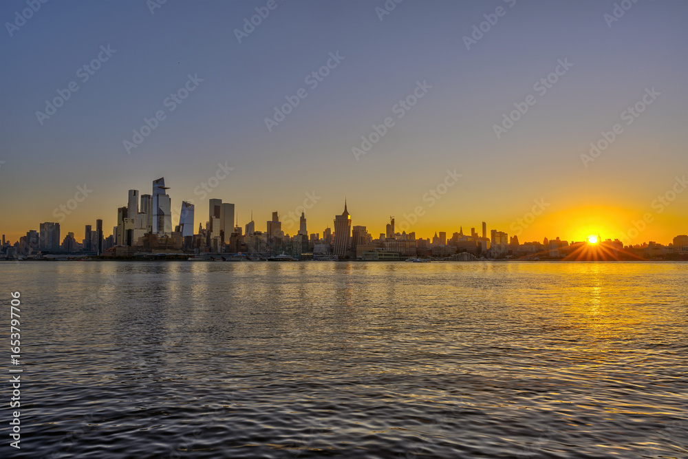 Fototapeta premium The skyline of Midtown Manhattan in New York City with the Hudson River at sunrise