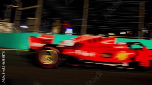 Red formula one race car speeds on a night track with blurred motion and glowing lights in the background. 4K video