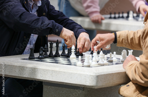 Two people playing chess on a table