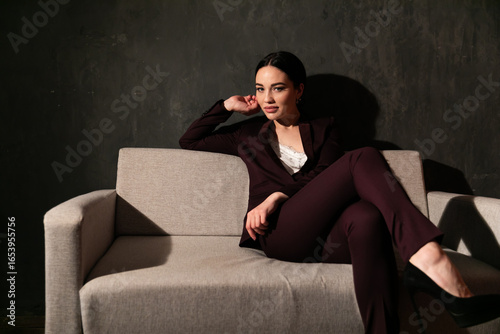 woman in business suit sitting on gray office sofa